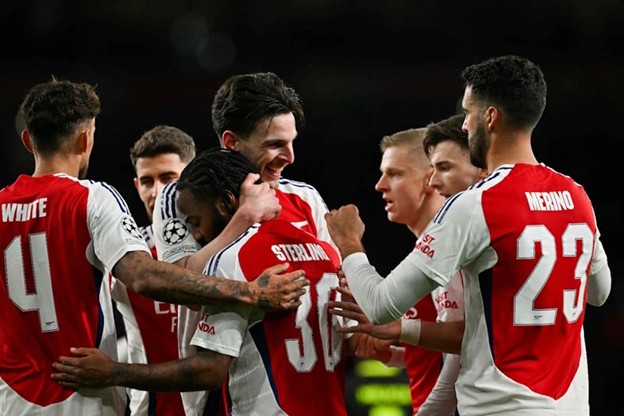 Arsenal players celebrate together after scoring during a UEFA Champions League match.