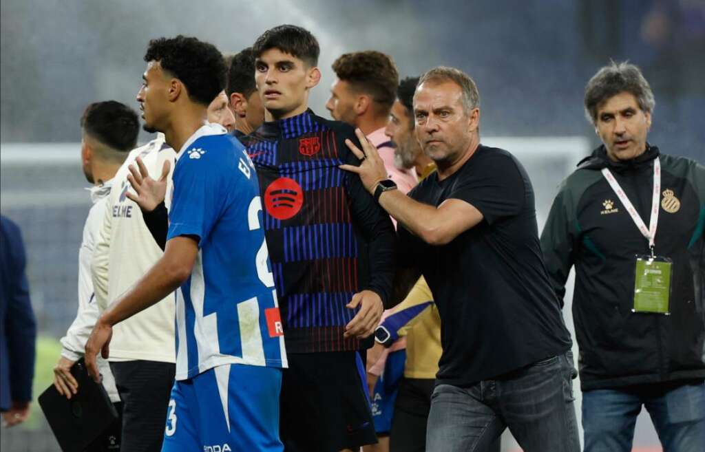 head coach Hansi Flick intervening to separate players during a chaotic post-match scene.