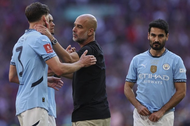 Man City manager Pep Guardiola consoles his players