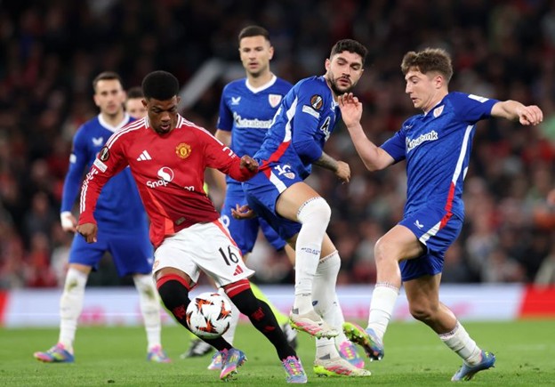 Manchester United’s Amad Diallo battles for the ball against Athletic Bilbao players during the 2024/25 UEFA Europa League semi-final second leg at Old Trafford.