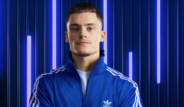 Florian Wirtz poses confidently in a blue Adidas tracksuit.