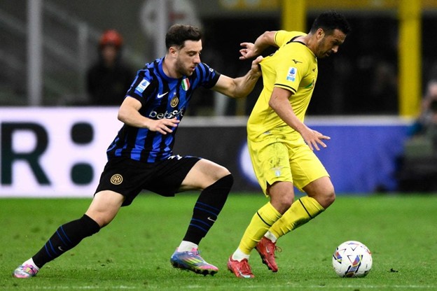 Inter Milan defender challenges Lazio forward Pedro during a Serie A match, with both players battling for possession.